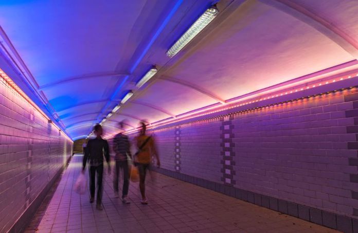 Lenvi image of people walking in a colourful tunnel