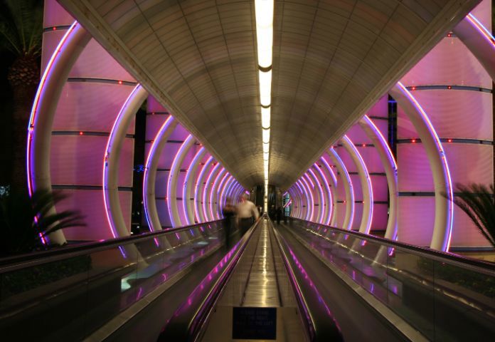 Beleuchteter futuristischer Tunnel mit Laufbändern, der einen scharfsinnigen, risikobasierten Ansatz für das Risikomanagement symbolisiert – Lenvi Insights