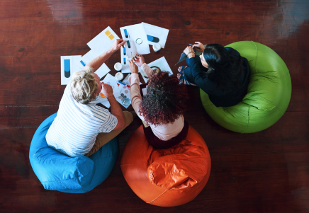 Three people collaborating on beanbags, symbolising integrated audit, standby servicing, and verification services - Lenvi Insights