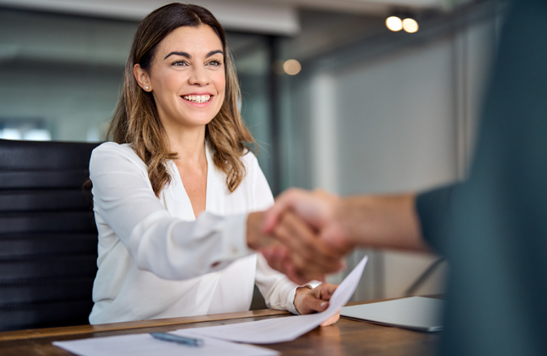 Smiling woman in a professional setting, representing improved efficiency and streamlined processes with Lenvi