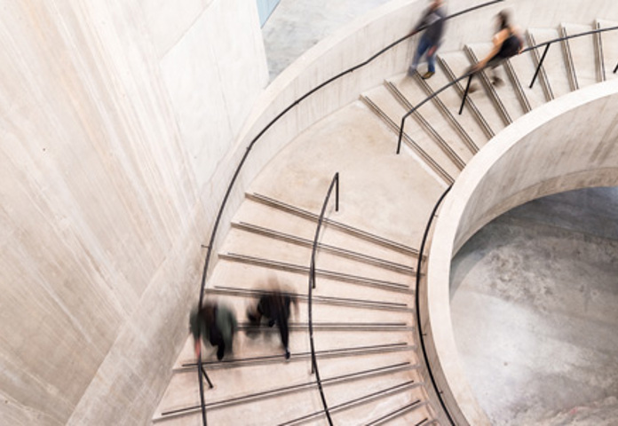 Top-down view of a spiral staircase with blurred people, representing a holistic approach to risk management by Lenvi Riskfactor