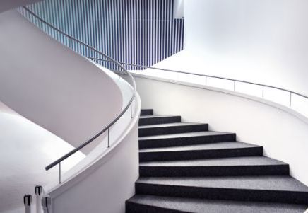 Lenvi banner image of a winding grey and white staircase with handrail