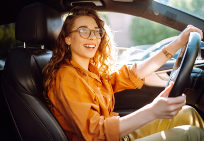Smiling woman driving a car, symbolising the UK auto ABS market in flux amidst regulatory uncertainty