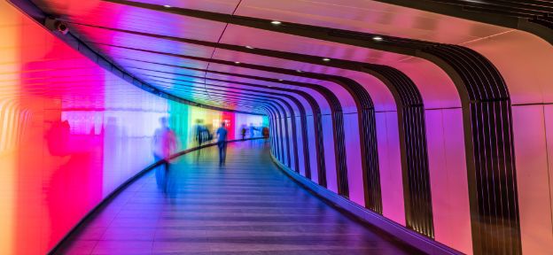 People walking in multi-coloured tunnel