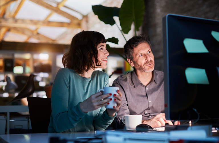 Lenvi QA professionals collaborating on a computer, demonstrating their quality assurance approach