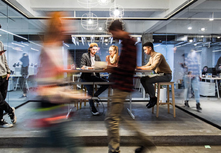 Busy modern office with blurred figures, symbolising choosing the right backup servicing solution - Lenvi Insights